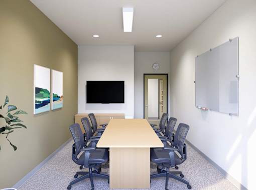 A conference room with a long table and chairs.