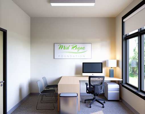 A room with a desk, chairs, and a computer monitor.
