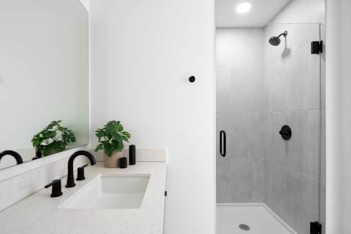 A modern bathroom with a white sink and a walk-in shower at Miles at Ybor Apartments, Florida, 33605