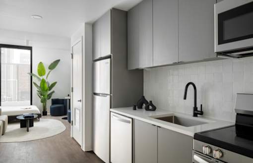A modern kitchen with white cabinets and a black stove top at Miles at Ybor Apartments, Tampa, FL