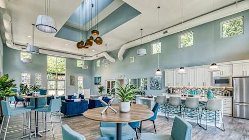 A modern open plan living and dining area with a kitchen in the background.