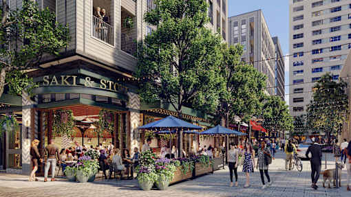 A busy street scene with people walking and sitting at tables outside a restaurant named Saki & Stone.