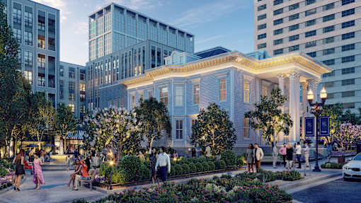 A white building with a porch and people walking around it.