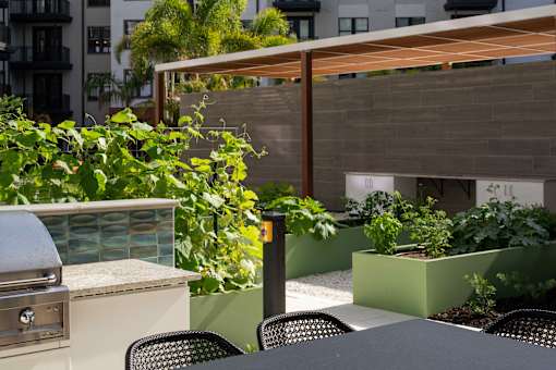A patio with a grill and chairs.
