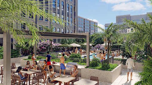 A group of people are sitting and standing on a patio with a pool.