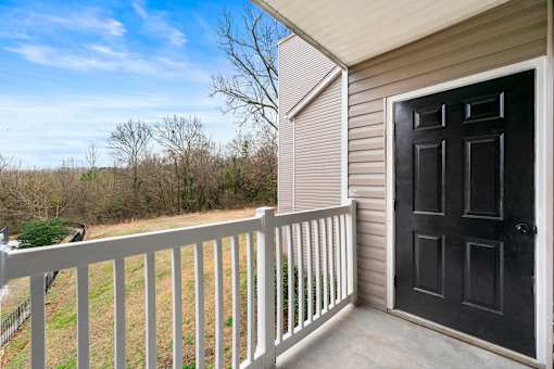 A black door is on the right side of a white railing at 2000 Oasis in Atlanta, GA 30316