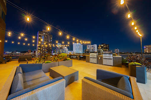 a roof top bar with a view of the city at night at ELEVATE Apartment Homes, Minnesota, 55403