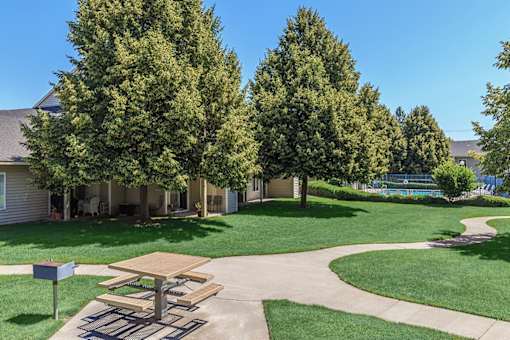 A picnic table is in the middle of a grassy area.