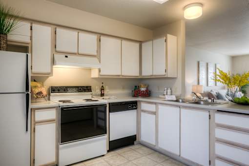 A kitchen with white appliances and cabinets.