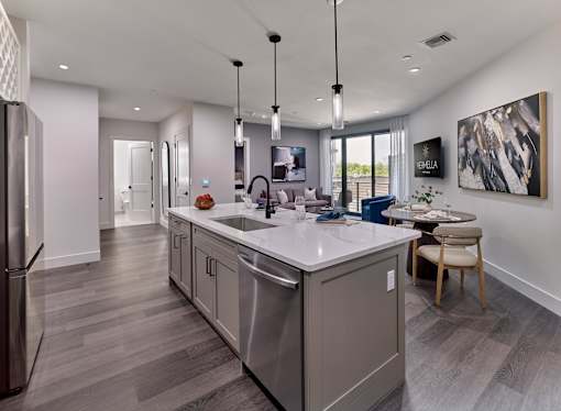 A modern kitchen with a large island and a dining area.