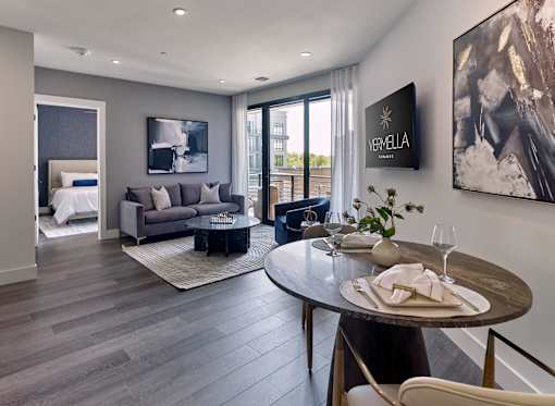 A modern living room with a dining table set for two.