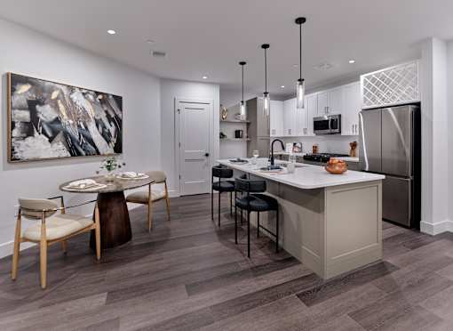 A modern kitchen with a dining table and chairs.