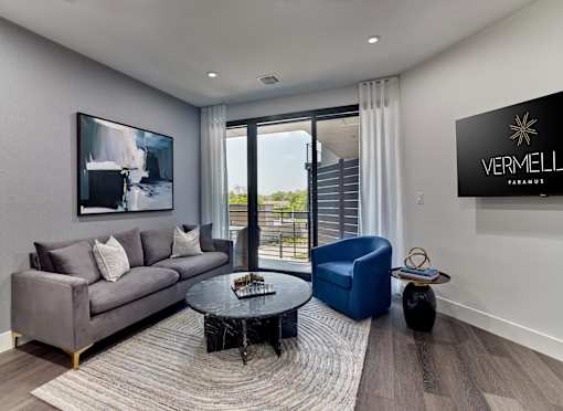 A living room with a grey couch, a black coffee table, and a blue chair.