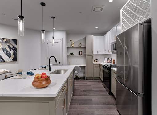 A modern kitchen with a bowl of apples on the counter.