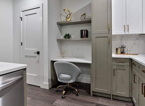 A white chair is in front of a desk in a kitchen.