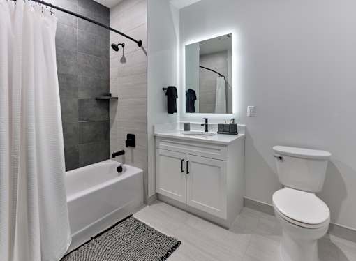 A white bathroom with a toilet, sink, and bathtub.