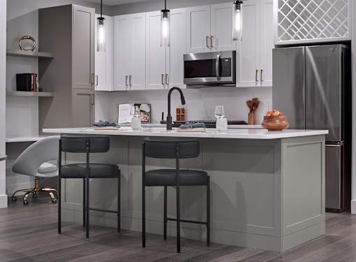 A kitchen with a white counter and black bar stools.