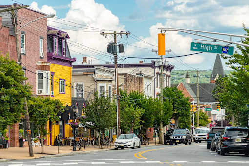 A street view of a town with cars parked on the side of the road.