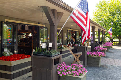A storefront with a large American flag hanging from the roof.