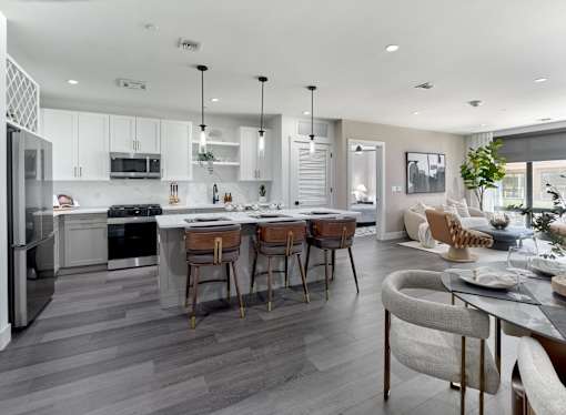 A modern kitchen with a dining area and a living room.
