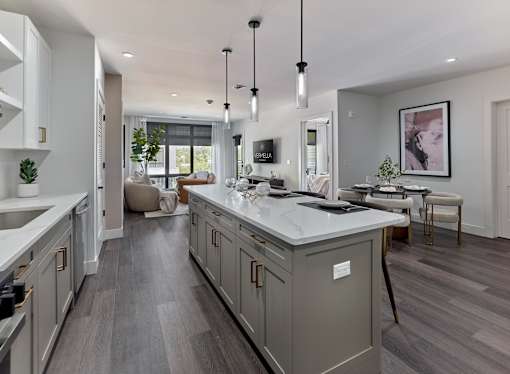 A modern kitchen with a large island and dark wood floors.