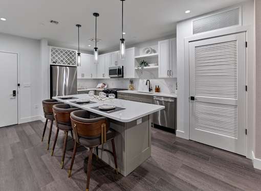 A modern kitchen with a large island and barstools.