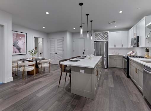 A modern kitchen with a dining table and chairs.