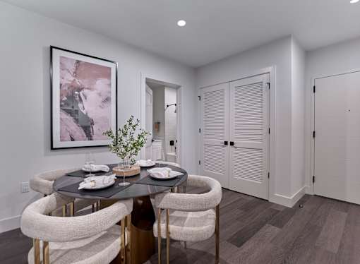 A dining room with a round table and chairs.