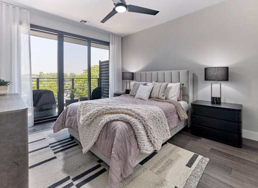 A bedroom with a large bed and a ceiling fan.