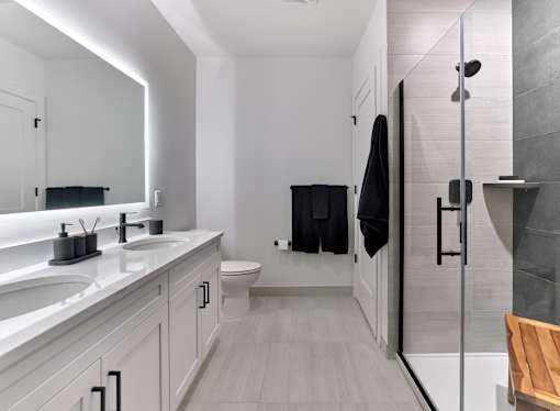 A modern bathroom with a walk-in shower and double sinks.