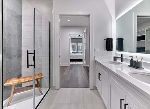 A modern bathroom with a walk-in shower and double sinks.