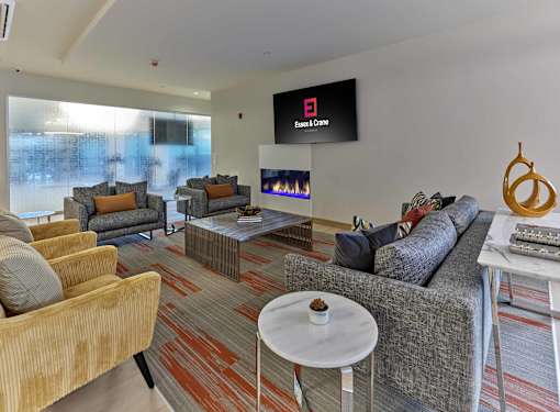 Luxury apartment clubroom with fireplace, lounge seating, and billiards at Essex & Crane, Orange NJ