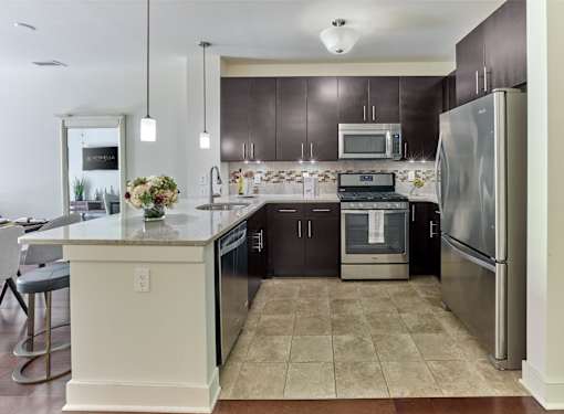 A kitchen with a white island and stainless steel appliances.