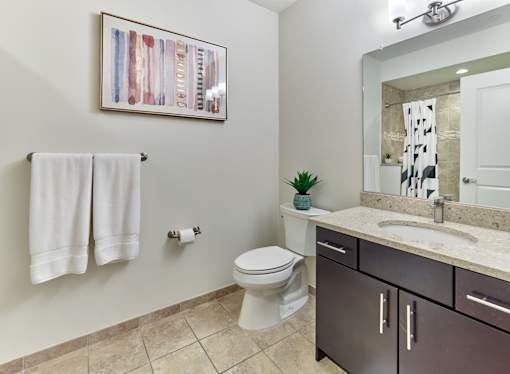 A bathroom with a toilet, sink, and a mirror.