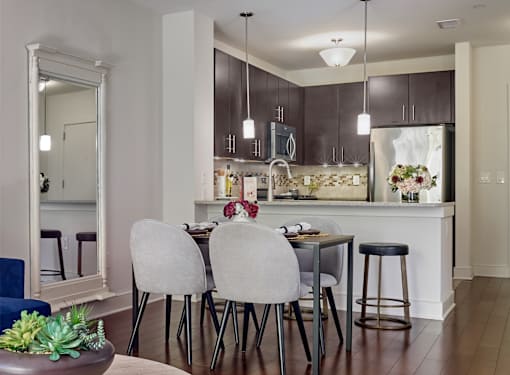 A kitchen with a dining table and chairs.