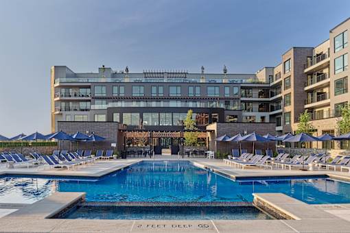 A large swimming pool in front of a building with a sign that says 2 feet deep.