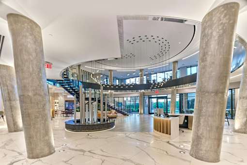 A large atrium with a circular ceiling design and a staircase in the background.