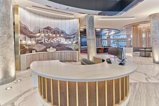 A reception area with a large desk and a wall mural.
