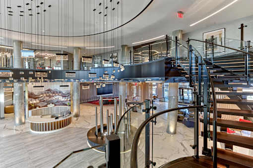A modern interior with a curved staircase and a glass wall.