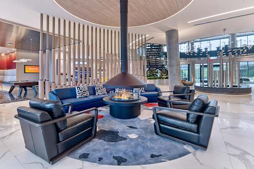 A modern living room with a fireplace and leather chairs.
