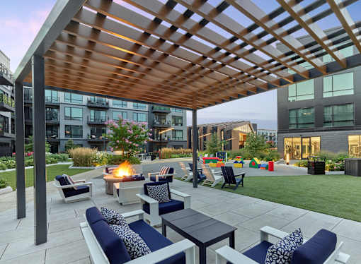 A patio with a fire pit and seating area.