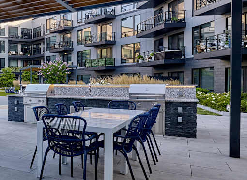 A patio with a table and chairs in front of a building.