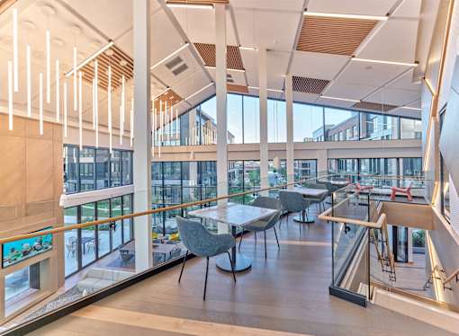 A modern interior with tables and chairs and a balcony.