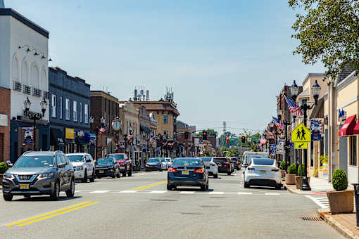 Cars are driving on a street with buildings on both sides.