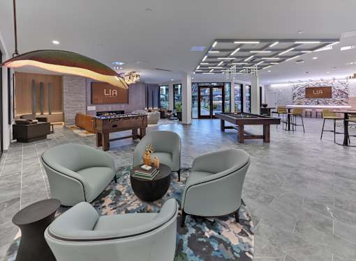 A modern club room with game tables, fire place, seating area