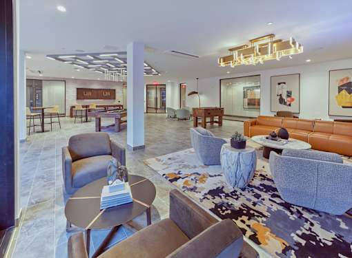 A modern living room with a variety of seating options and a large rug.