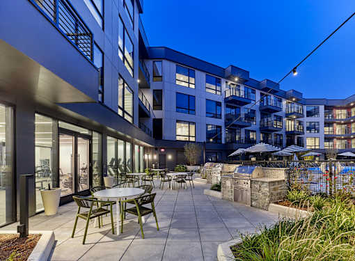 A modern building with a pool and a patio area.