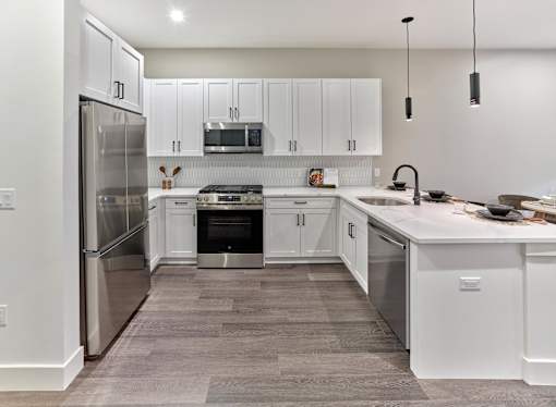 A modern kitchen with white cabinets and stainless steel appliances.