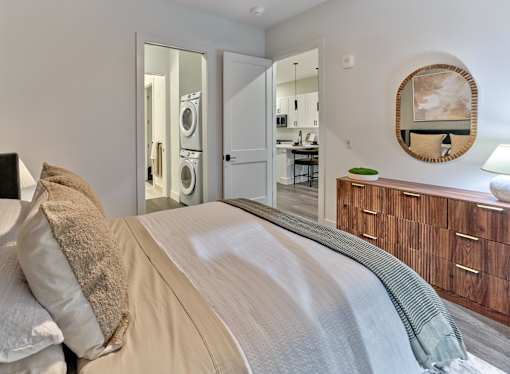 A bedroom with a large bed and a mirror on the wall.