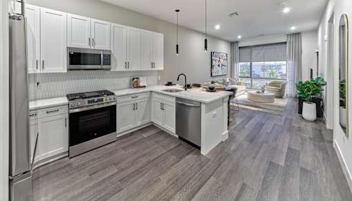 A modern kitchen with white cabinets and stainless steel appliances.